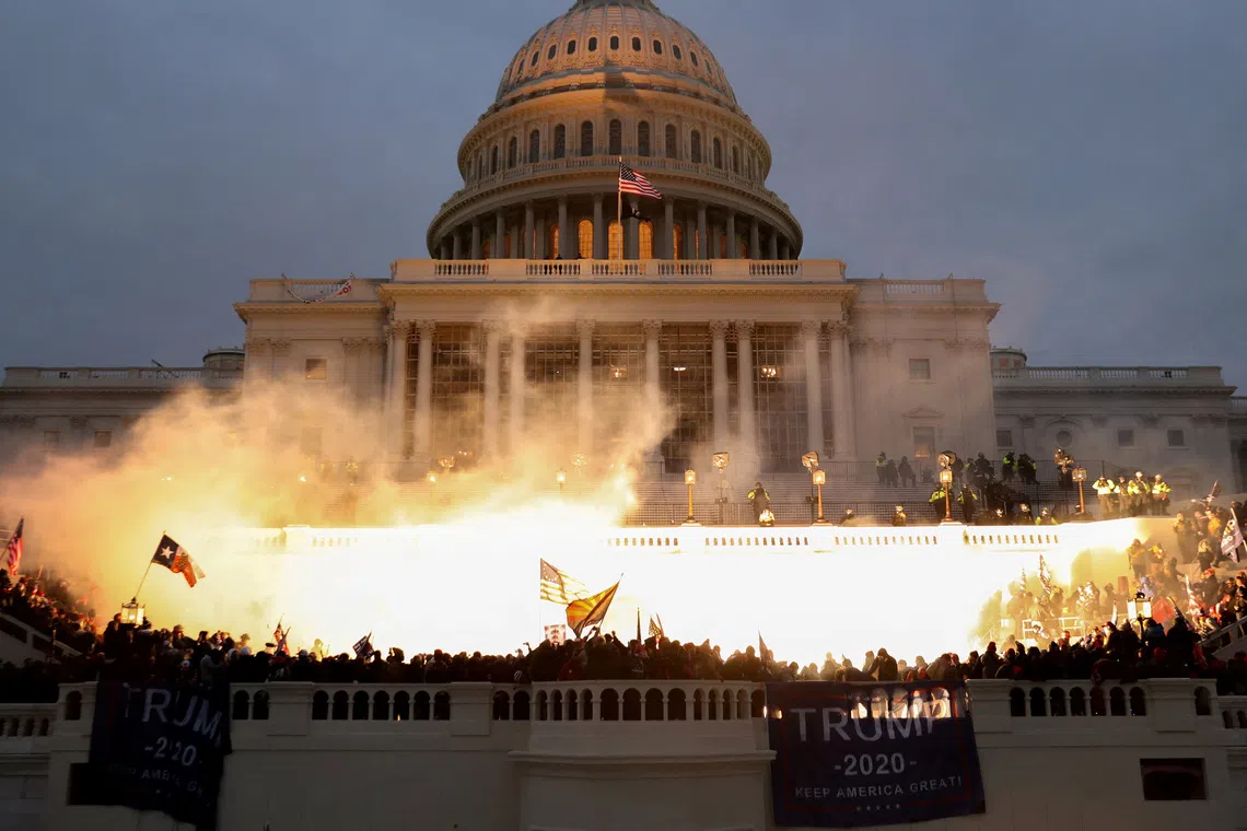 FILE PHOTO: An explosion caused by a police munition is seen while supporters of U.S. President Donald Trump riot in front of the U.S. Capitol Building in Washington, U.S., January 6, 2021. REUTERS/Leah Millis/File Photo