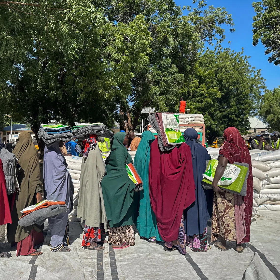 Women displaced by the floods line up to receive a bag of rice each in Baga road, Maiduguri Nigeria October 31, 2024. REUTERS/Abraham Achirga