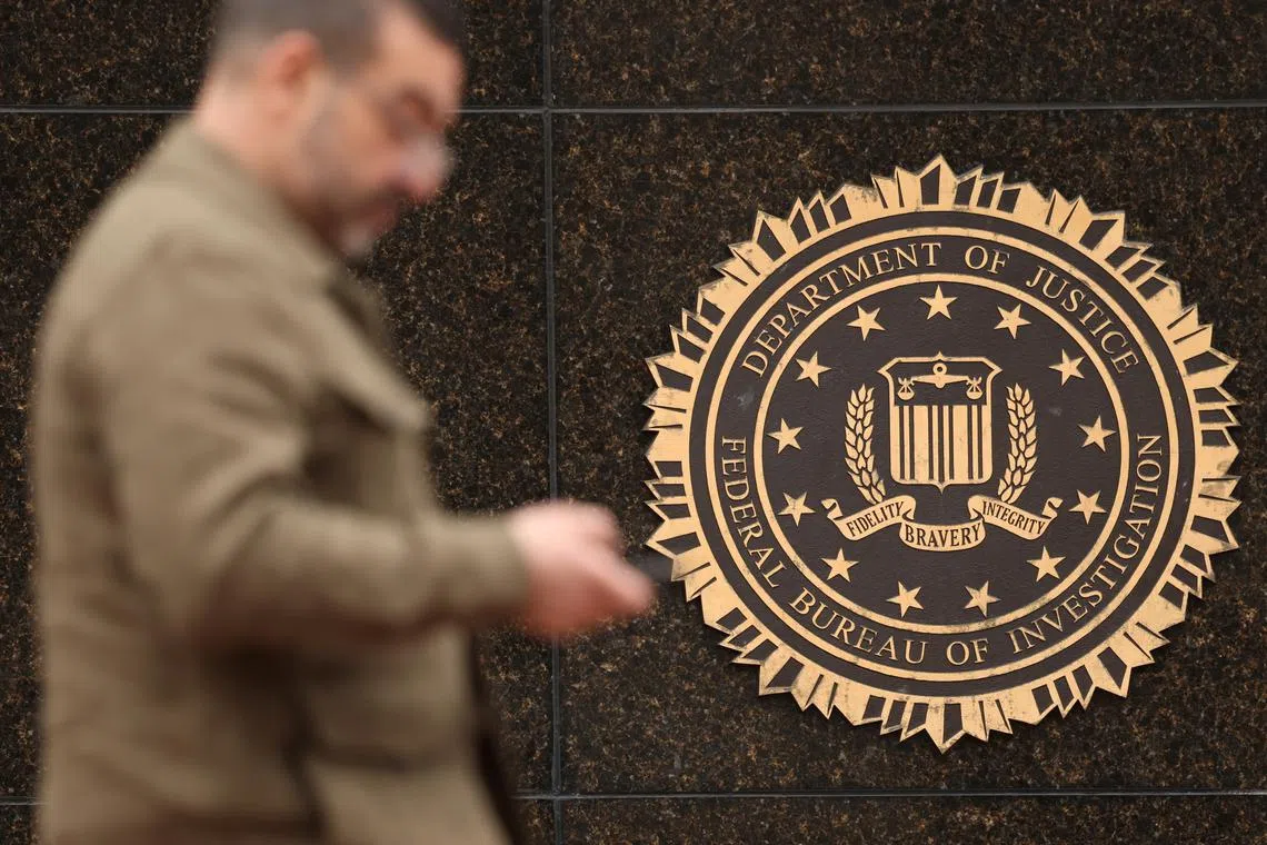 A person passes by the FBI seal on the wall of the FBI headquarters, days after the Trump administration launched a sweeping round of cuts at the Justice Department, in Washington, U.S., February 3, 2025. REUTERS/Kevin Lamarque/File Photo