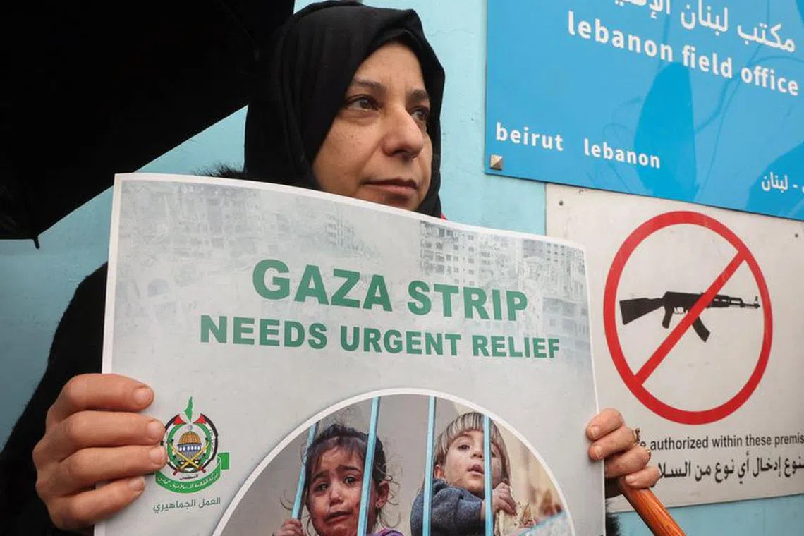 A Palestinian woman holds a placard during a protest against the suspension of UNRWA funding by some Western states, in front of the United Nations Palestinian aid agency UNRWA's building in Beirut, Lebanon January 30, 2024. REUTERS/Mohamed Azakir