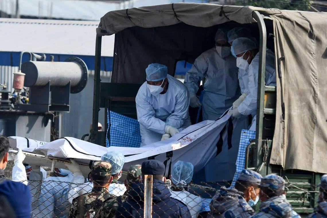 Nepal's army and volunteers carry the body of a victim who died in a plane crash in Pokhara, Nepal, on Jan 17, 2023.