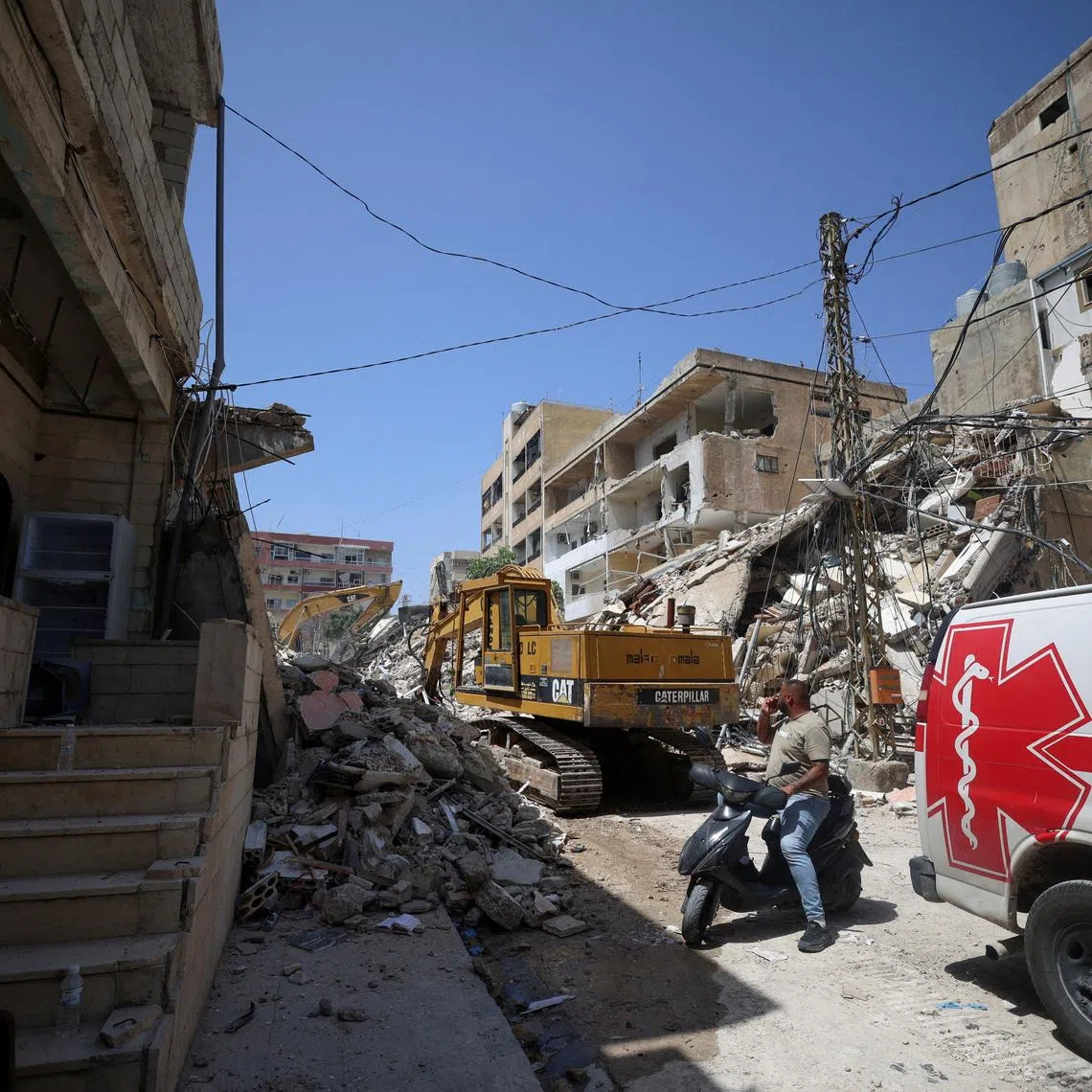 A man next to an ambulance looks at the site of an Israeli strike carried out before a 10-day ceasefire between Lebanon and Israel went into effect, in Tyre, Lebanon, April 17, 2026. REUTERS/Louisa Gouliamaki