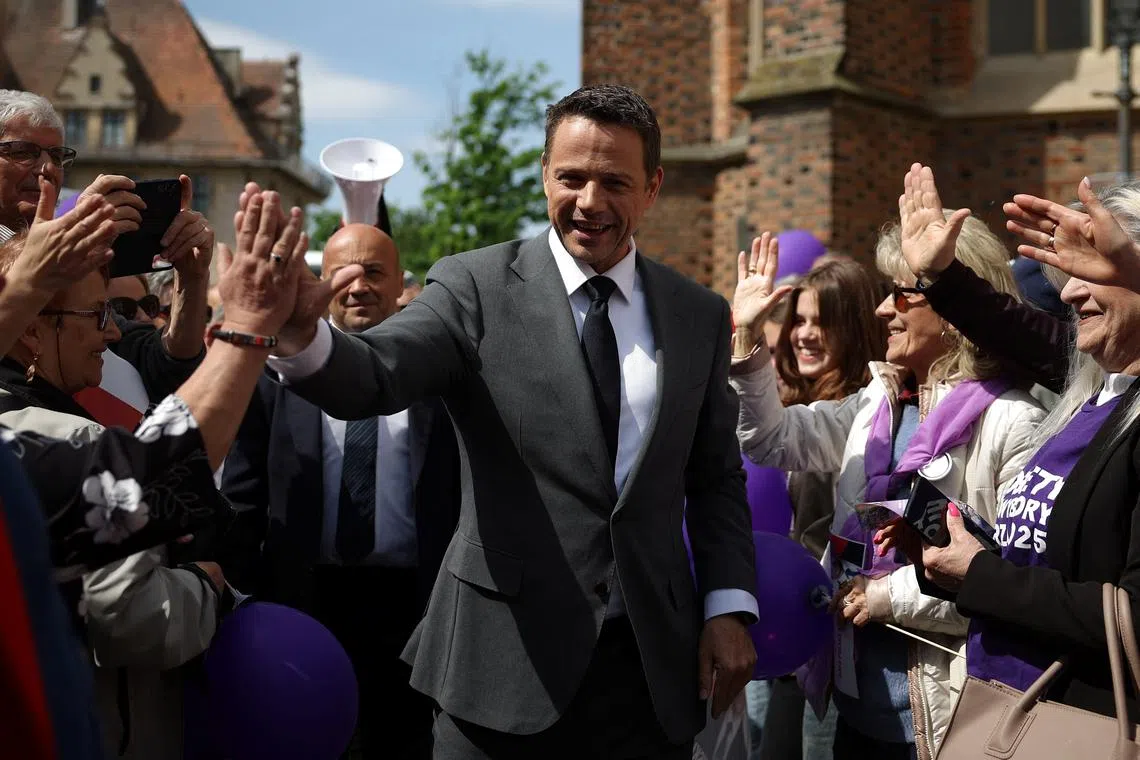 Civic Coalition presidential candidate, Warsaw Mayor Rafal Trzaskowski gives a high five to his supporter during an election meeting in Brzeg, Poland, May 14, 2025. REUTERS/Kacper Pempel/File Photo