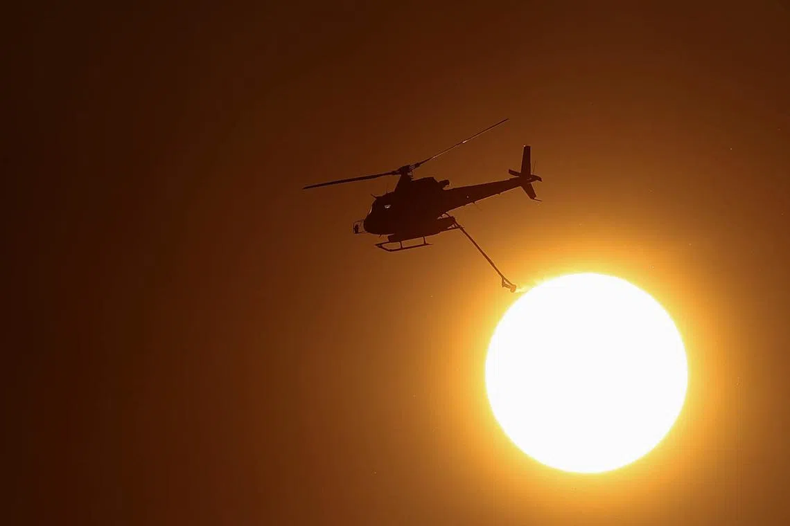A firefighting helicopter flies against the backdrop of the sun over a wildfire near Cotignac, in the Var department amid worsening drought conditions following a heatwave and water shortages across much of the country, France, July 23, 2026. REUTERS/Manon Cruz TPX IMAGES OF THE DAY