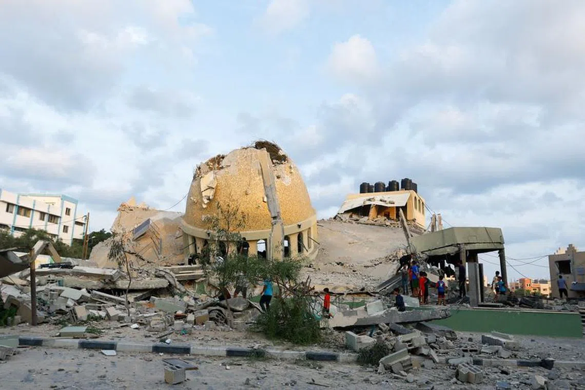 Palestinians inspect a mosque destroyed in Israeli strikes in Khan Younis, in the southern Gaza Strip, October 8, 2023. REUTERS/Ibraheem Abu Mustafa