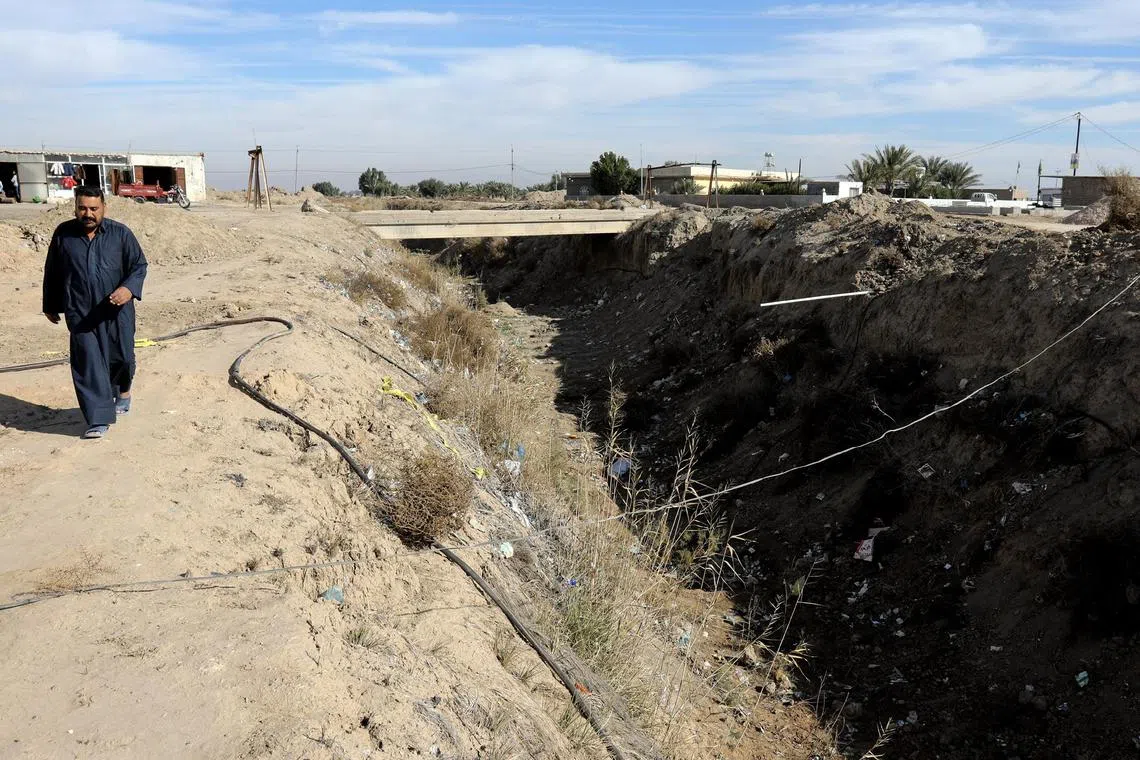 epa11068033 An Iraqi man walks next to a dried-up irrigation canal at a rural area in the south of Babil province, central Iraq, 08 January 2024 (issued 10 January 2024). Iraq is facing the worst drought in decades due to water scarcity and lack of rainfall in recent years which forced the majority of the rural population in the villages of Babil province to migrate to the cities. According to the Iraqi Ministry of Water Resources, the country is facing its worst water shortage in a century, with about 7 million people experiencing reduced access to water.  EPA-EFE/AHMED JALIL