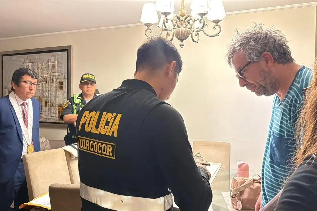 A member of the Peru National Police speaks with Piero Corvetto, the former head of Peru’s National Office of Electoral Processes (ONPE), during a raid at his residence as part of a new investigation into alleged electoral irregularities, after he resigned this week over delays in counting votes from the April 12 general election, in Lima, Peru, in this handout distributed on April 24, 2026. Policia Nacional de Peru/Handout via REUTERS