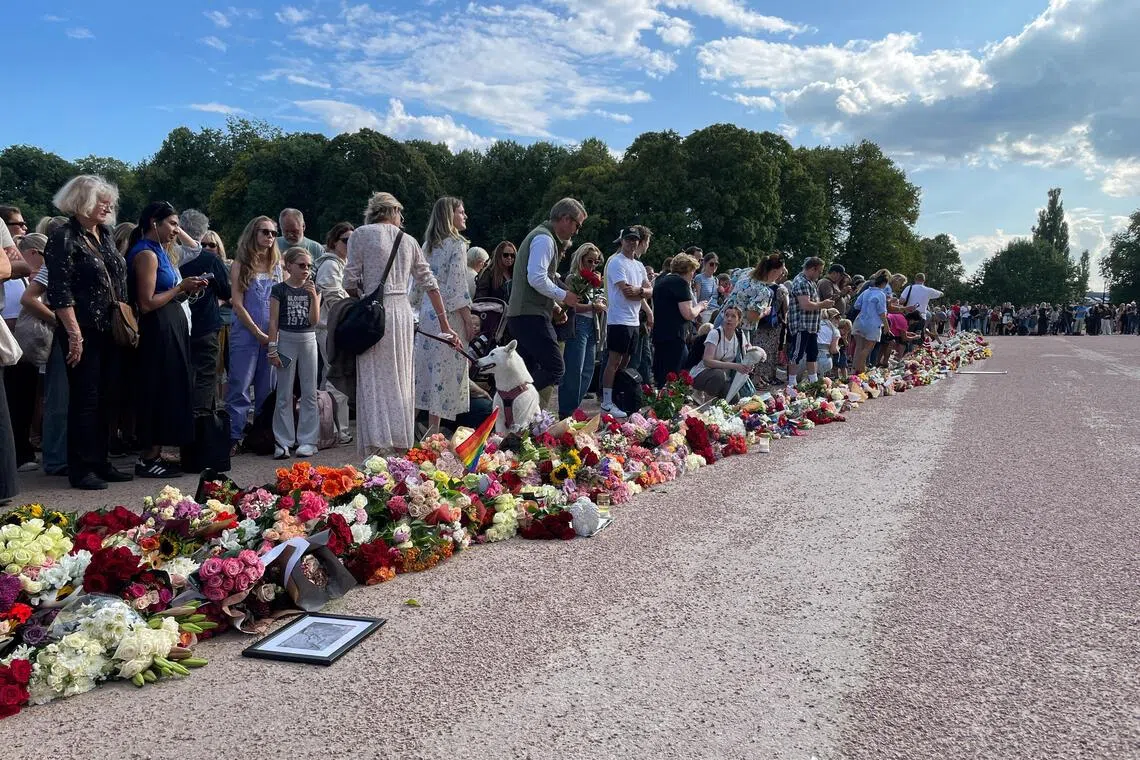 Hundreds of people gathering outside the Royal Palace in Oslo on Aug 27, 2026, with many laying flowers, as Norway’s King Harald is hospitalised.