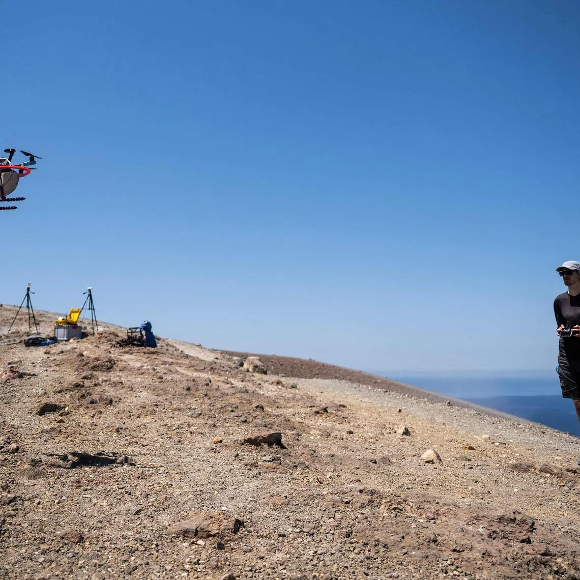 A vulcanologist from the University of Munich pilots a drone with a mirror used to reflect a laser and collect data from gas emissions in the crater of La Fossa, on Vulcano Island.