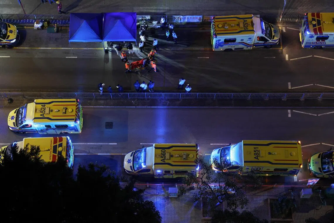 A person receives medical attention, as fire burns bamboo scaffolding across multiple buildings at Wang Fuk Court housing estate, in Tai Po, Hong Kong, China, November 26, 2025. REUTERS/Tyrone Siu