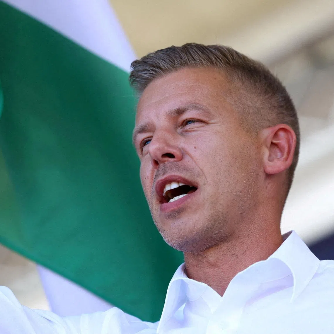 FILE PHOTO: Peter Magyar, leader of the opposition Tisza party, waves a Hungarian flag at a rally near the venue of ruling Fidesz party closed doors meeting where Prime Minister Viktor Orban discusses campaign issues with party officials in Kotcse, Hungary September 7, 2025. REUTERS/Bernadett Szabo/File Photo