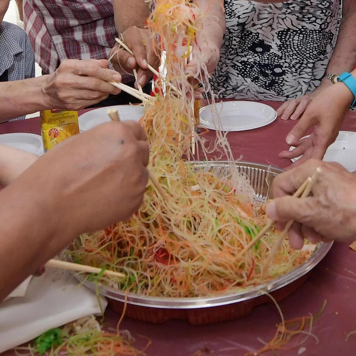 People tossing yusheng during Chinese New Year for luck and prosperity.