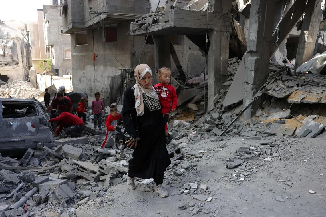 A Palestinian woman walking amid the destruction following Israeli strikes in the northern Gaza Strip on May 22.
