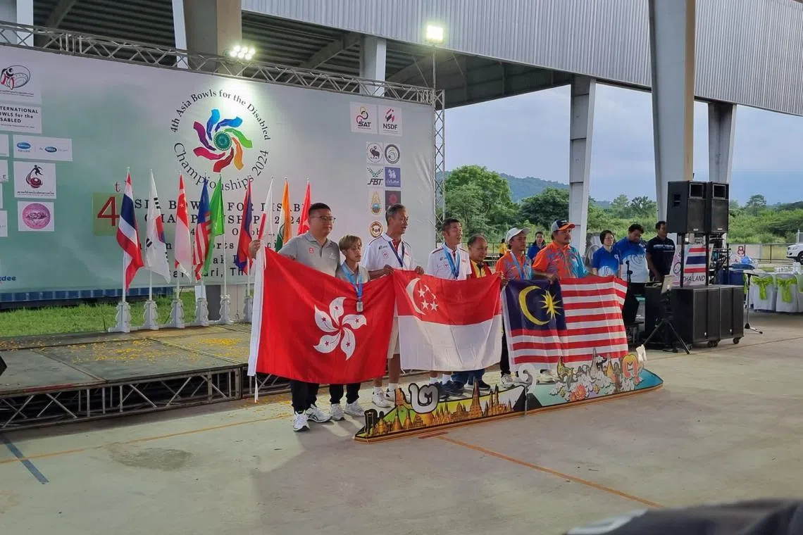 Koh Kwee Boon (fourth from left) and his director Gary Goh (third from left) struck gold in the B2 men's singles event at the Asia Bowls for the Disabled Championships.