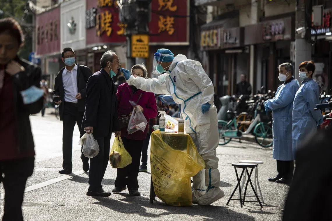 A healthcare worker collects a swab sample for Covid-19 from a resident in Shanghai on Nov. 6, 2022.