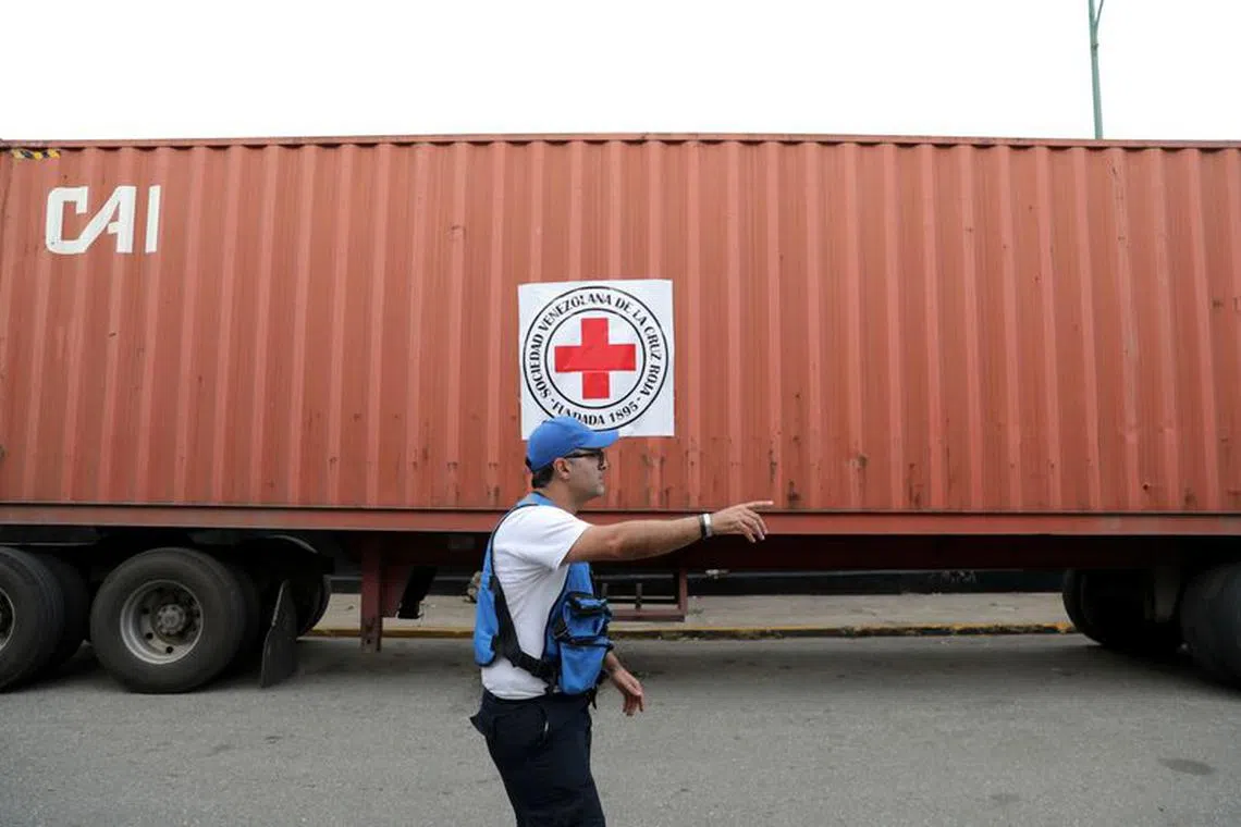 A volunteer gestures near a container truck bearing a logo of the International Federation of Red Cross and Red Crescent Societies (IFRC) that arrived carrying humanitarian aid to be stored in a warehouse in Caracas, Venezuela July 31, 2019. REUTERS/Manaure Quintero/File photo