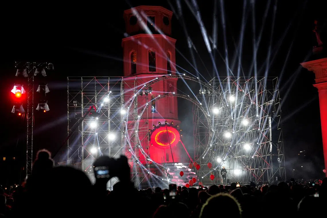 People watch light illumination during Lithuanian capital's 700th anniversary celebration with the festival of lights in Vilnius, Lithuania Jan 25, 2023. 
