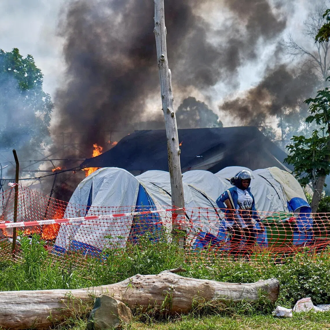A crowd set fire to Ebola treatment tents in Rwampara, Democratic Republic of Congo, on May 21, after soldiers fired tear gas and warning shots to defuse tensions over the burial of a local footballer who had died from the disease.