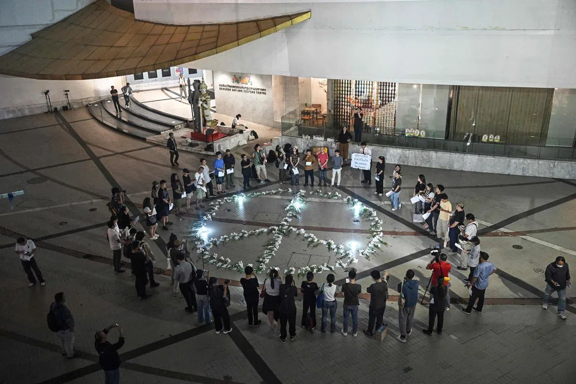 People gather around a peace symbol to demand justice for the victims of the October 2004 incident known as the Tak Bai massacre, when scores of Muslim protesters suffocated in army trucks.