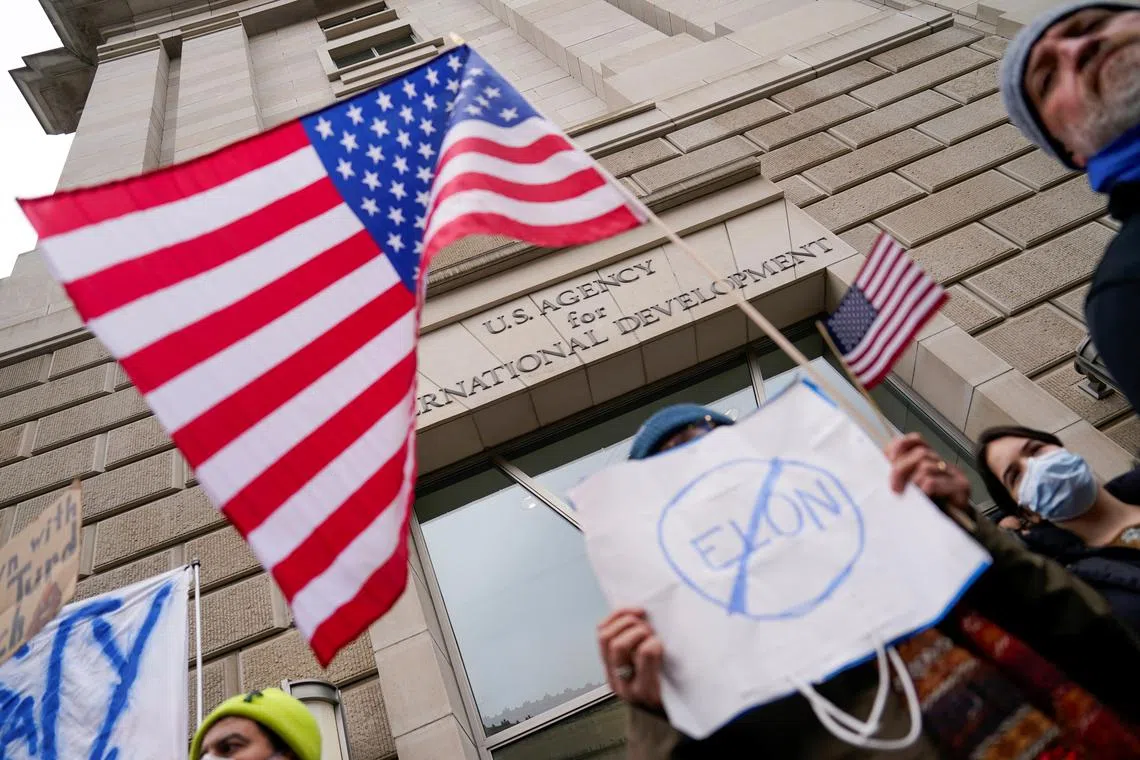 People hold placards outside the USAID building, after billionaire Elon Musk, who is heading U.S. President Donald Trump's drive to shrink the federal government, said work is underway to shut down the U.S. foreign aid agency USAID, in Washington, U.S., February 3, 2025. REUTERS/Kent Nishimura