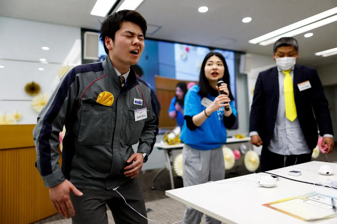 Masaya Shibasaki, 26, an employee of EXEO Group Inc., reacts as he tries the Osaka Heart Cool developed VR electrical device 'Perionoid' which releases electrical stimulation that feels like experiencing women's menstrual pain during a workshop ahead of the International Women's Day at the company headquarters in Tokyo, Japan March 7, 2024.  REUTERS/Issei Kato