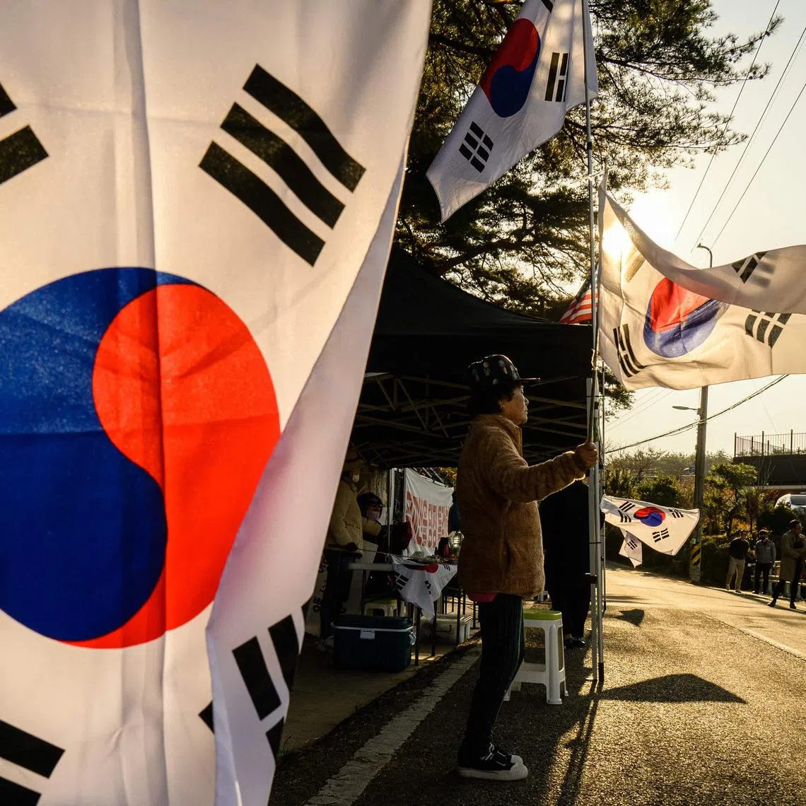 A protestor waves a South Korean national flag in village of Pyeongsan, in Yangsan on Nov 16, 2002.