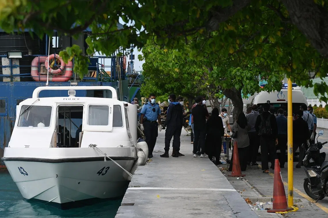 The bodies of two Italian divers being transferred from a police boat to an ambulance in Male on May 19.