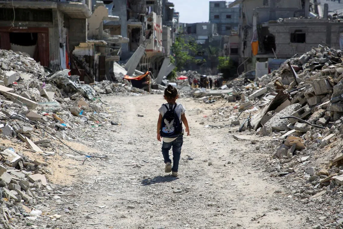 A Palestinian student walks between the rubble, as war disrupts a new school year, amid the Israel-Hamas conflict, in Khan Younis, in the southern Gaza Strip, September 4, 2024. REUTERS/Hatem Khaled/File Photo