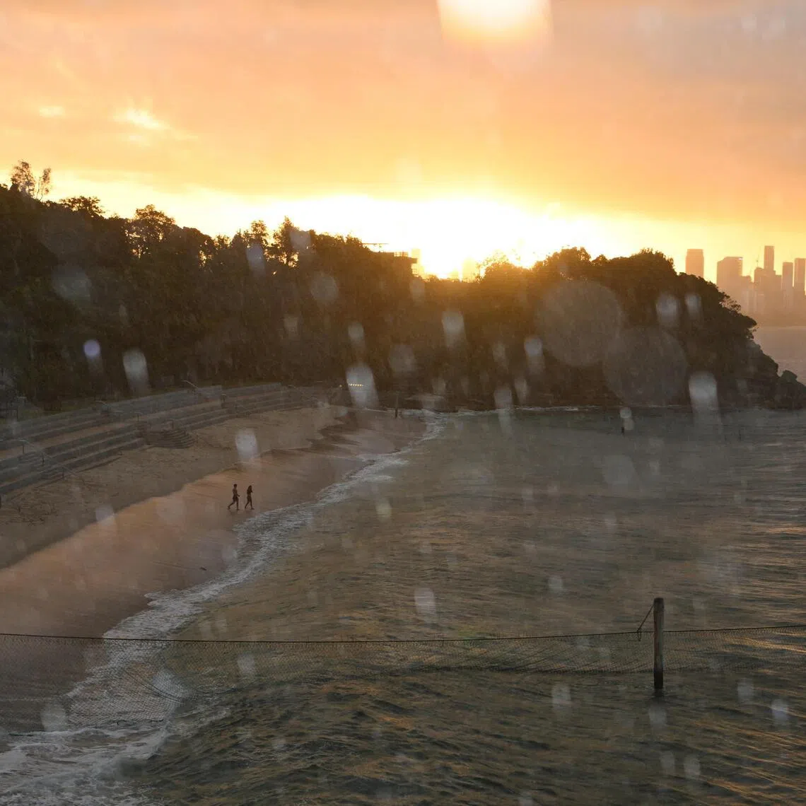 A view of rainfall over Shark Beach at sunset in Sydney, Australia, January 18, 2026. REUTERS/Flavio Brancaleone     TPX IMAGES OF THE DAY     