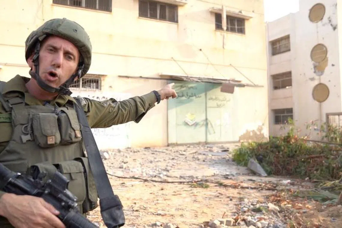 Israeli military spokesperson Rear Admiral Daniel Hagari shows what he says is the house of a senior Hamas naval commander located next to a school at a location given as Gaza, in this still image taken from video released November 13, 2023.   Israel Defense Forces/Handout via REUTERS/ File photo