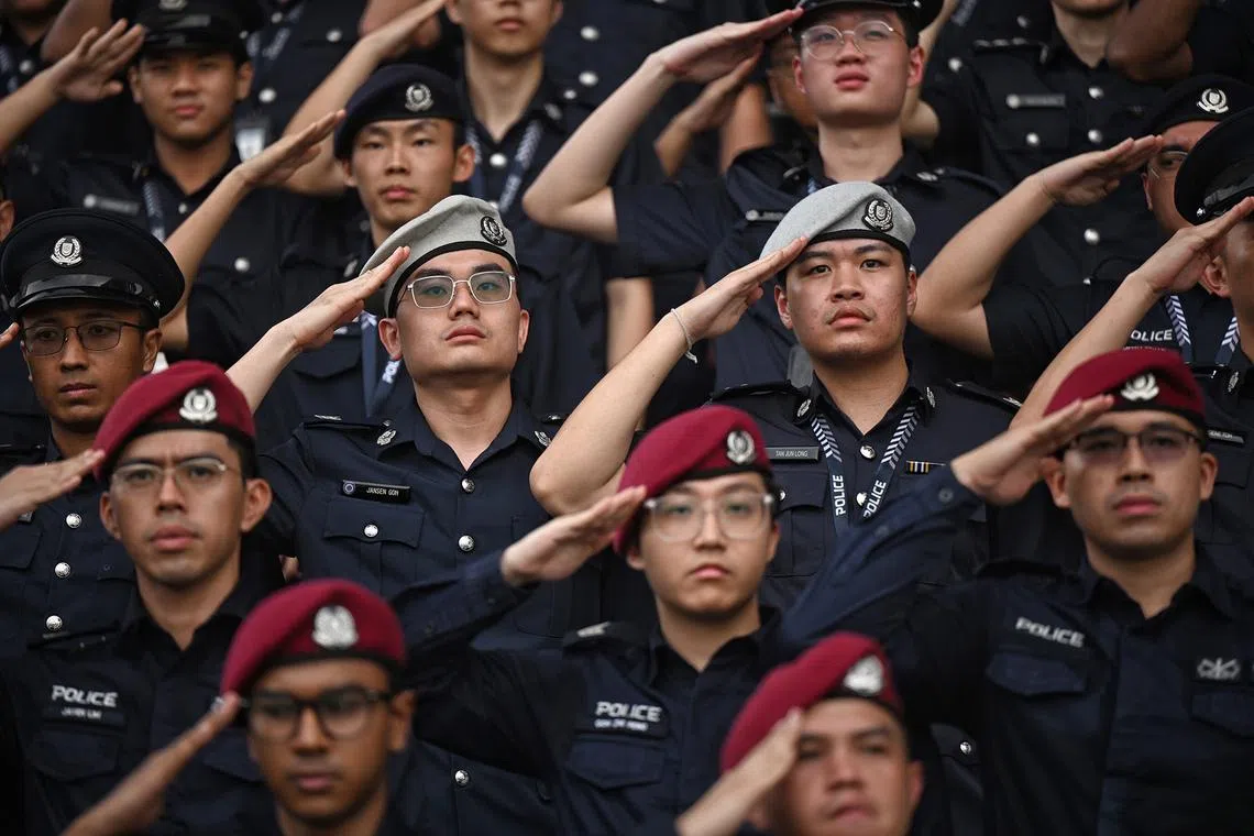 Uniformed officers saluting during the national anthem at the Singapore Police Force’s Police Day Parade on June 3, 2026. 