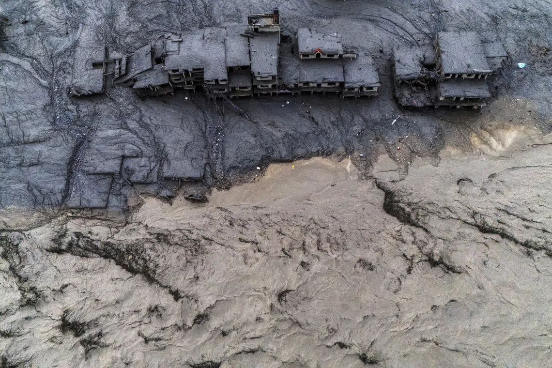 A drone view shows damaged buildings covered in mud next to the Likhu River following deadly flash floods and mudslides in Devighat, Nuwakot district, Nepal, on Aug 30.