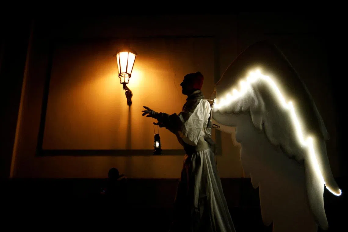 A man dressed as an angel walking through a street as a part of Christmas celebrations in Prague, Czech Republic, Dec 17, 2023. 