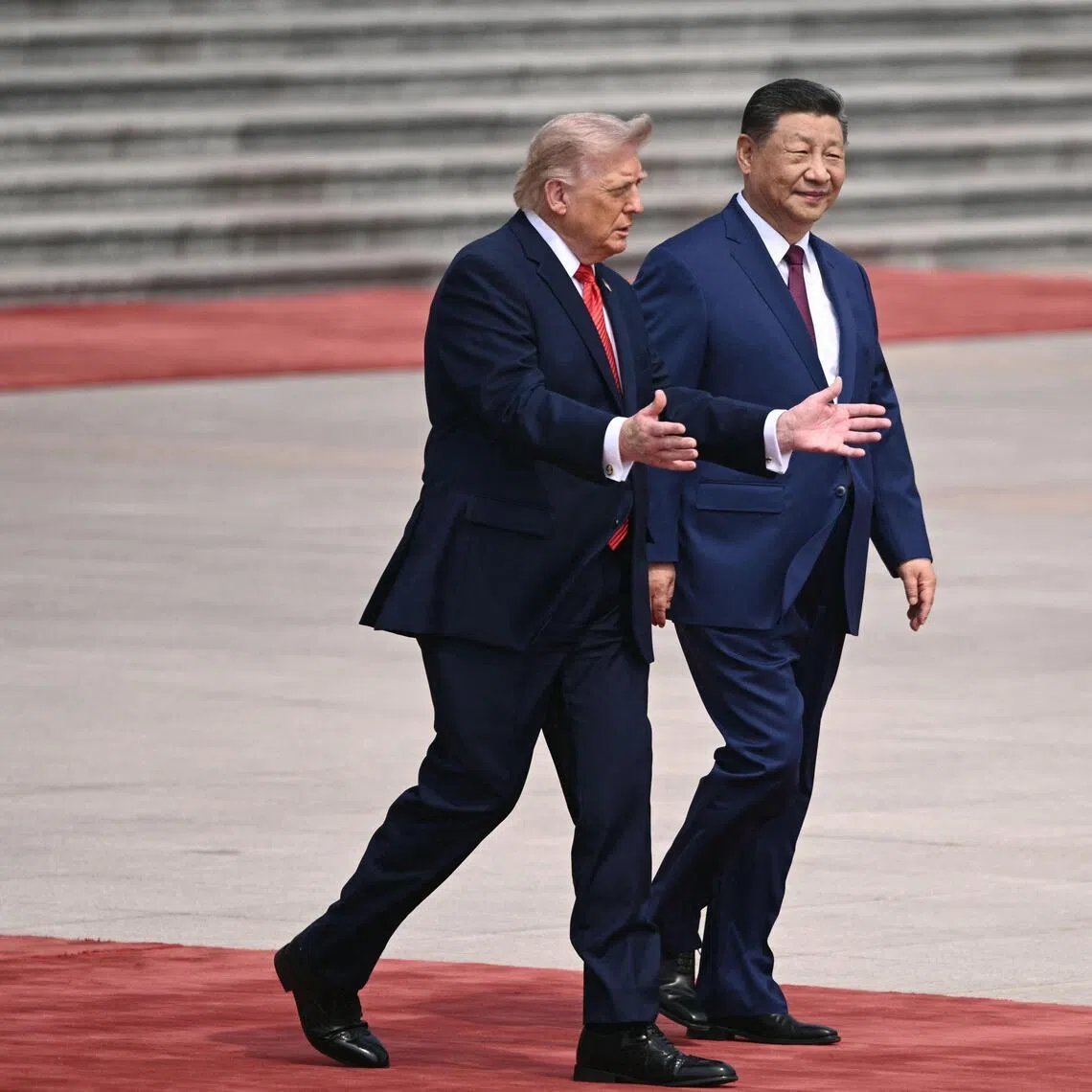 US President Donald Trump (left) takes part in a welcome ceremony with China's President Xi Jinping at the Great Hall of the People in Beijing on May 14, 2026.