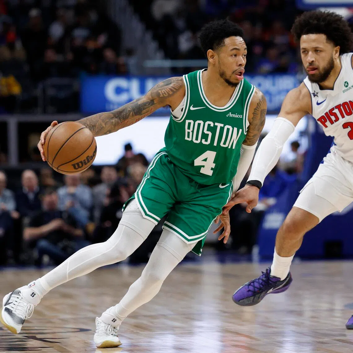 Boston Celtics guard Anfernee Simons dribbles the ball against Detroit Pistons guard Cade Cunningham in the first half at Little Caesars Arena. 
