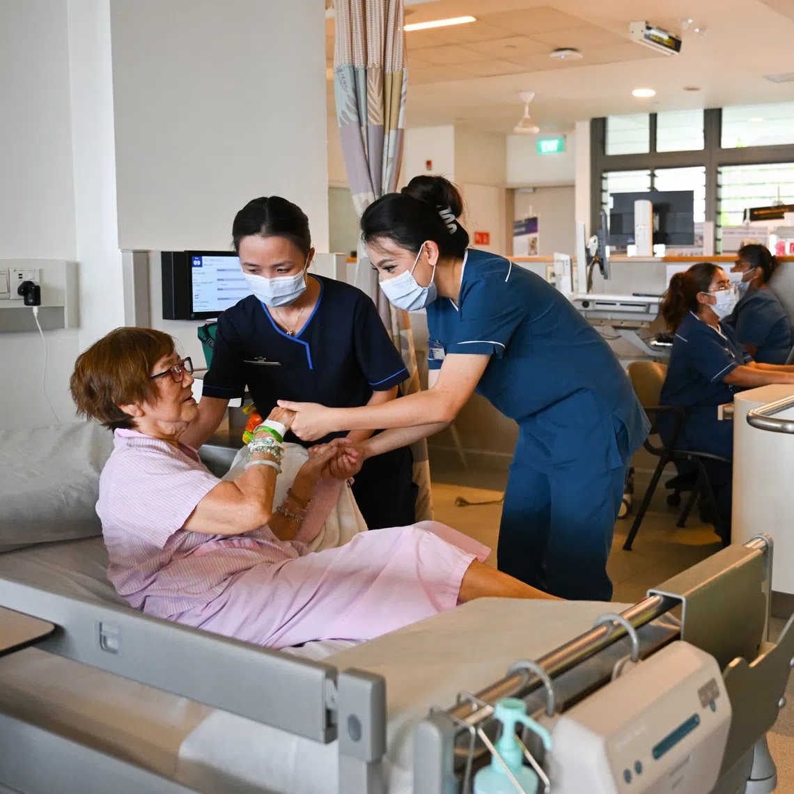Senior occupational therapist Giang Thuy Anh (standing, left) and senior staff nurse Siti Nur Aisyah Ibrahim with a patient at Yishun Community Hospital.