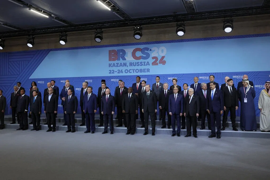 Russian President Vladimir Putin and participants in the outreach/BRICS Plus format meeting pose for a family photo during the BRICS summit in Kazan, Russia, 24 October 2024. MAXIM SHIPENKOV/Pool via REUTERS