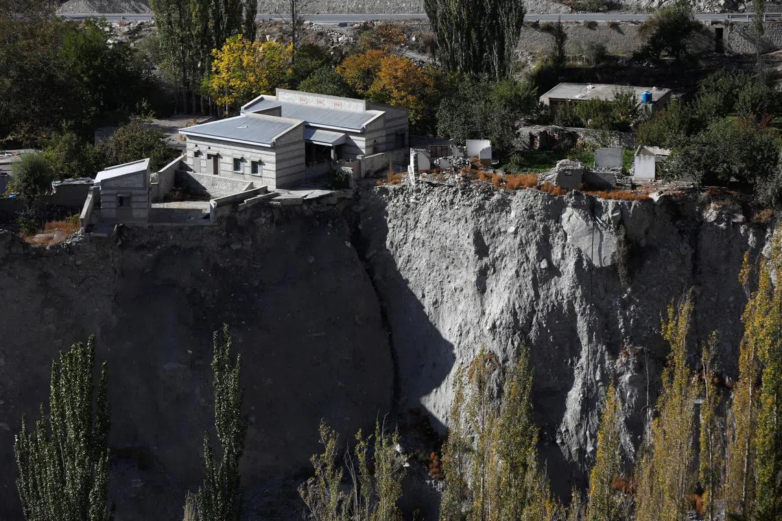 A community hall and houses showing signs of damage after a Glacial Lake Outburst Flooding (GLOF) incident occurred from the nearby Shisper glacier, in Hassanabad village, Hunza valley, in the Karakoram mountain range in the Gilgit-Baltistan region of Pakistan, Oct 10, 2023. 