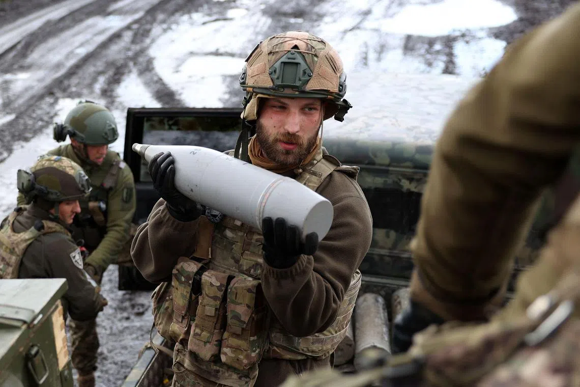 A Ukrainian serviceman holds an artillery shell at a front line position near Bakhmut, in Ukraine's Donetsk region.