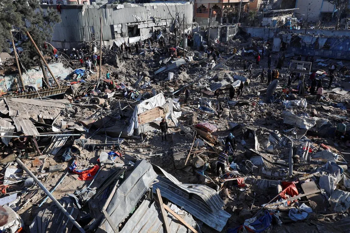 Palestinians inspect the site of an Israeli strike on an UNRWA school sheltering displaced people, in the Bureij camp in the central Gaza Strip, May 7, 2025. REUTERS/Ramadan Abed