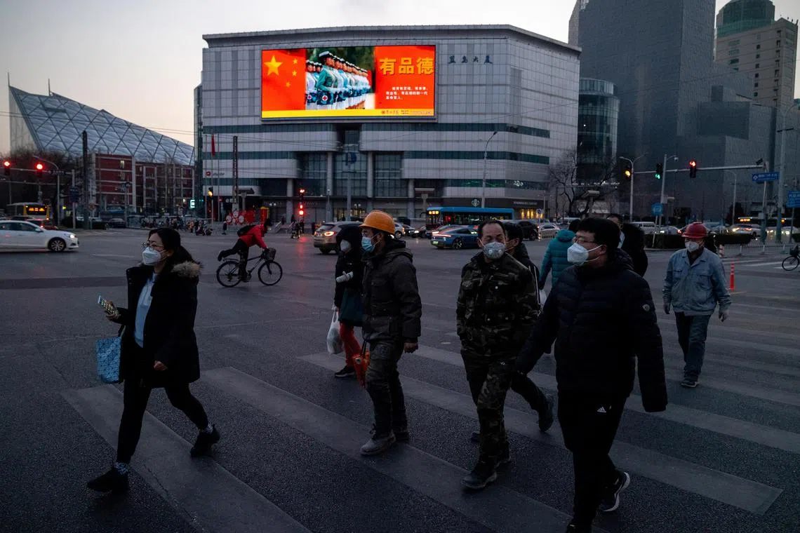 A street crossing in Beijing, where a big screen shows a PeopleÕs Liberation Army video, Dec. 20, 2022. For a powerful government that has bragged about its command of the country, its absence at a moment of crisis has made the public question the legitimacy and the credibility of the Chinese Communist Party. (Andrea Verdelli/The New York Times)