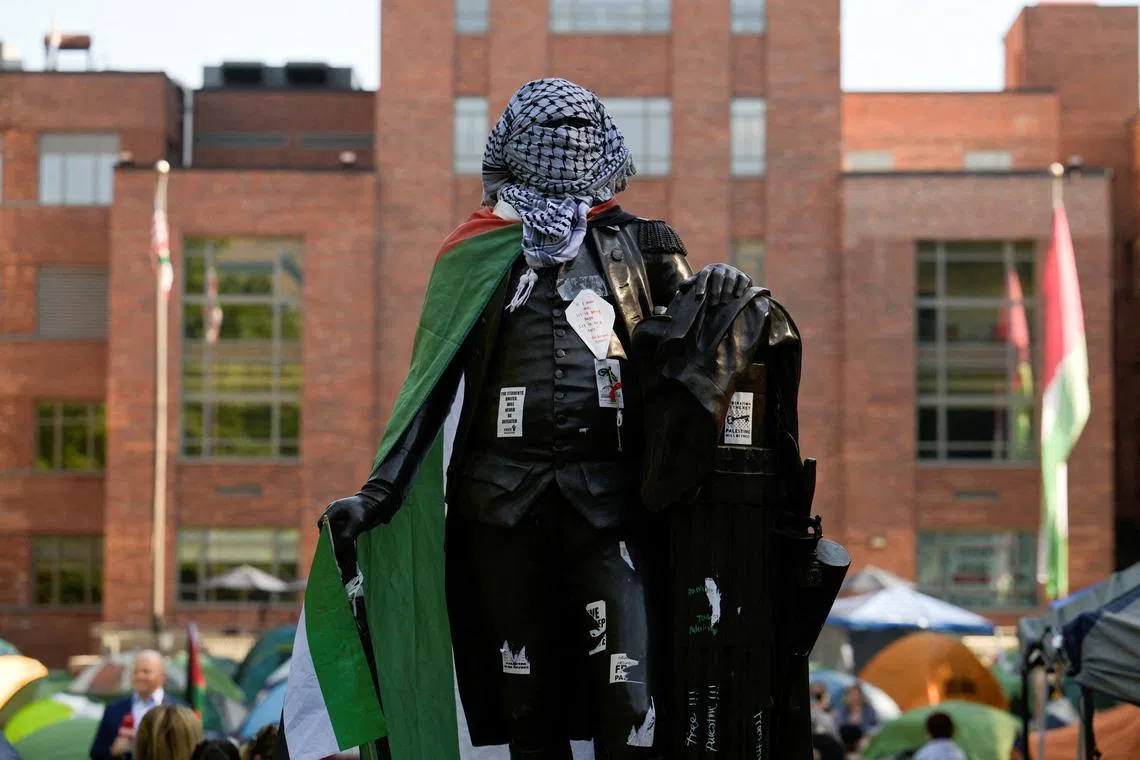 FILE PHOTO: A statue of George Washington tied with a Palestinian flag and a keffiyeh inside a pro-Palestinian encampment is pictured at George Washington University in Washington, DC, U.S., May 2, 2024. REUTERS/Craig Hudson/File Photo