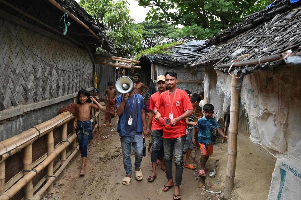 UN workers alerting refugees in a Rohingya camp ahead of Cyclone Mocha's landfall, in Teknaf, Bangladesh.