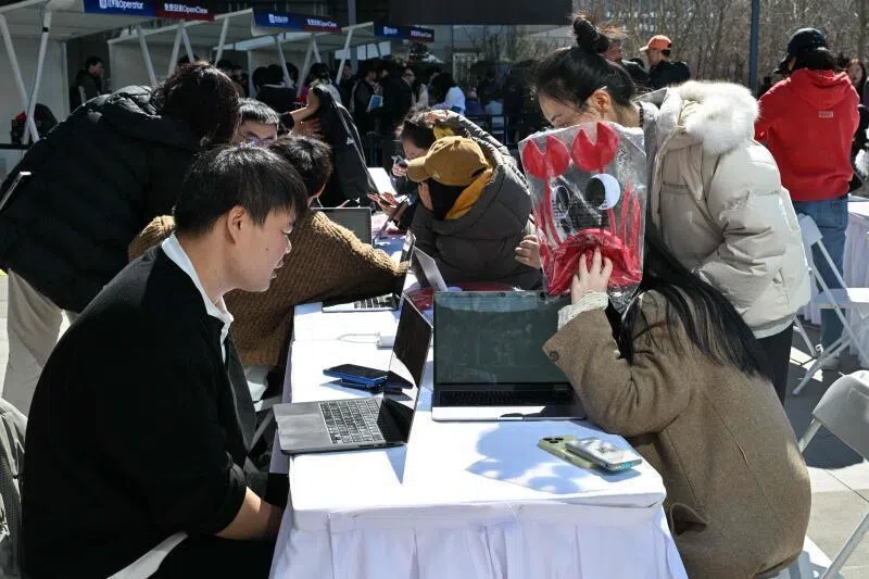 Engineers (left) install and set OpenClaw, an open-source AI assistant for users at the Baidu headquarter in Beijing on March 11. 