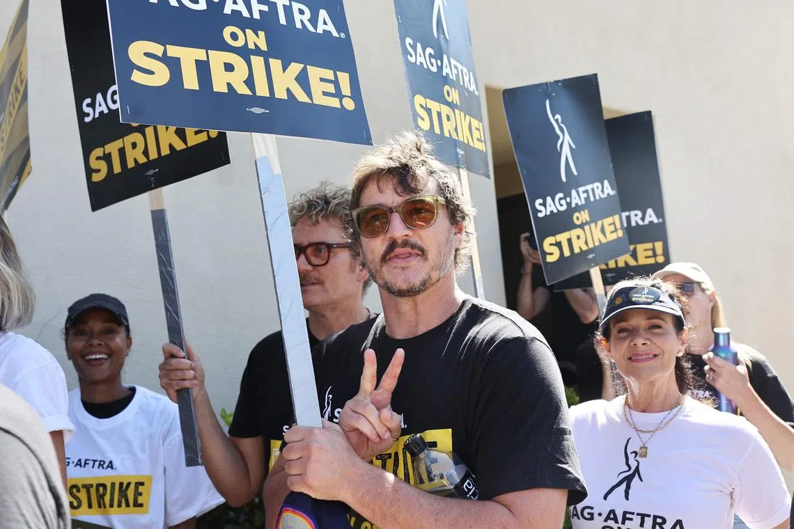 Actor Pedro Pascal (centre) walks the picket line with striking SAG-AFTRA members outside Warner Bros. Studio as the actors strike continues on Sept 26, 2023 in Burbank, California. 