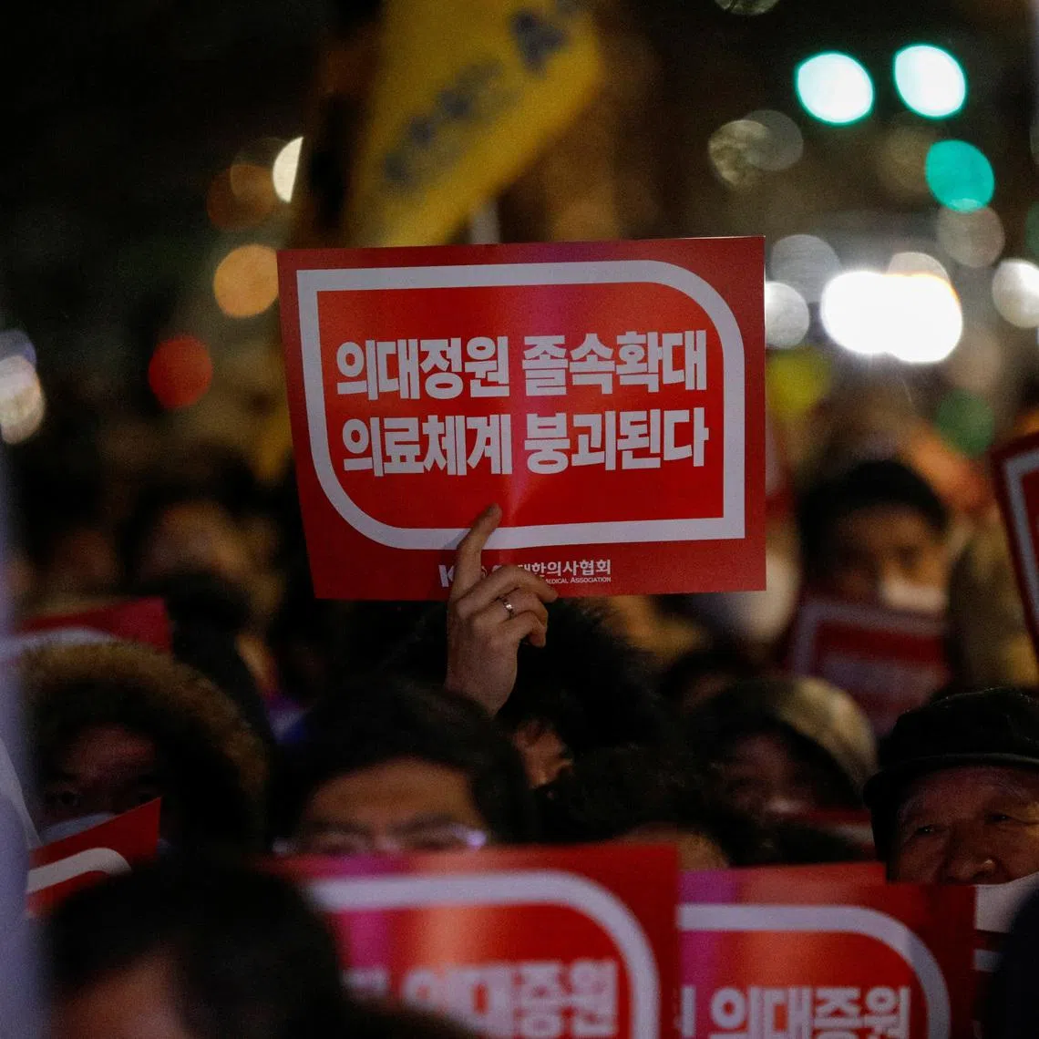FILE PHOTO: A doctor holds a slogan in a protest against a plan to admit more students to medical school, in front of the Presidential Office in Seoul, South Korea, February 22, 2024. REUTERS/Kim Soo-Hyeon/File Photo