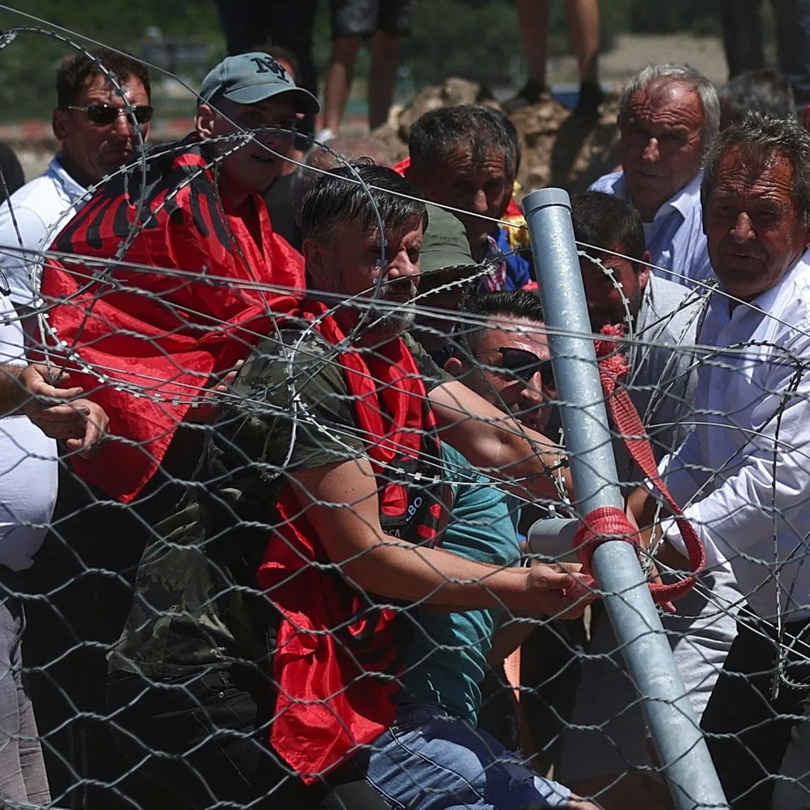 Protesters who say their land has been taken unjustly tear down the fence where a tourist resort is to be built by the Adriatic coast, in Rrjoll, near Shkodra, Albania, June 13, 2026. REUTERS/Florion Goga