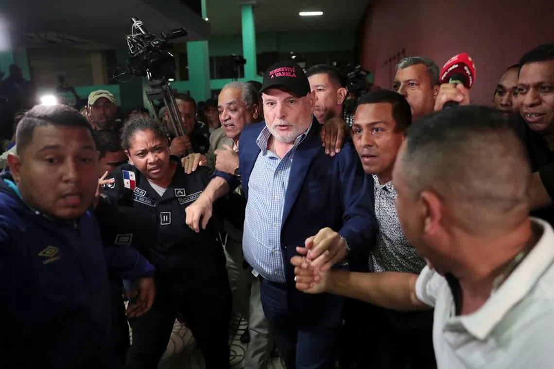Panama's former president Ricardo Martinelli is escorted by police officers and supporters while leaving a courthouse after being declared not guilty of spying charges in Panama City, Panama August 9, 2019. Martinelli's cap reads, \"I survived Varela\", referring to Panama's former president Juan Carlos Varela. REUTERS/Erick Marciscano/File Photo
