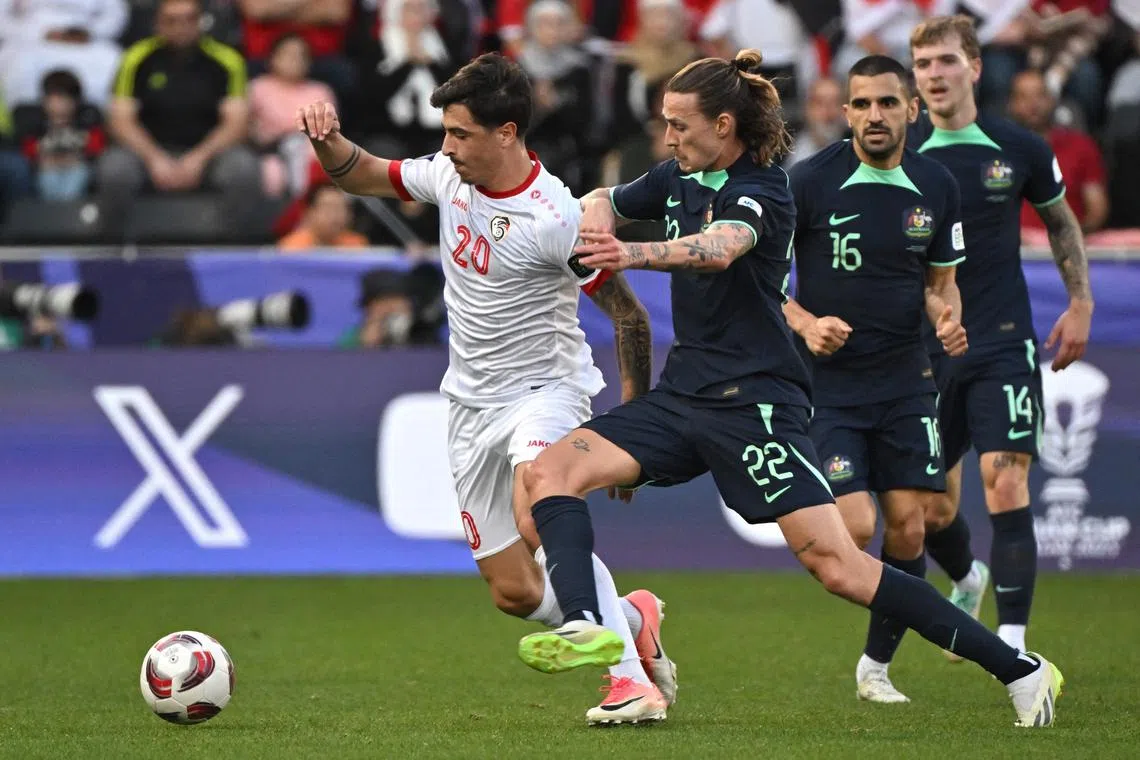 Syria forward Antonio Yakoub (left) and Australian midfielder Jackson Irvine vie for the ball.