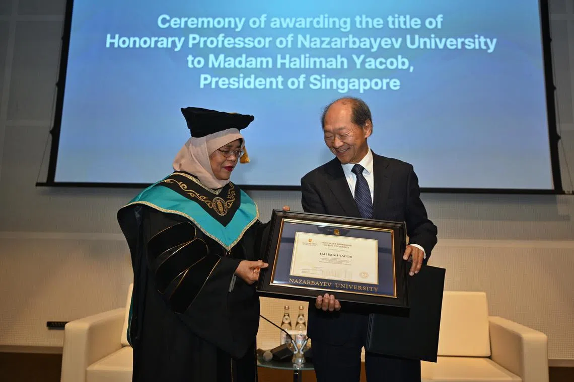 President Halimah Yacob receiving the title of Honorary Professor from Shigeo Katsu , President of Nazarbayev University. 